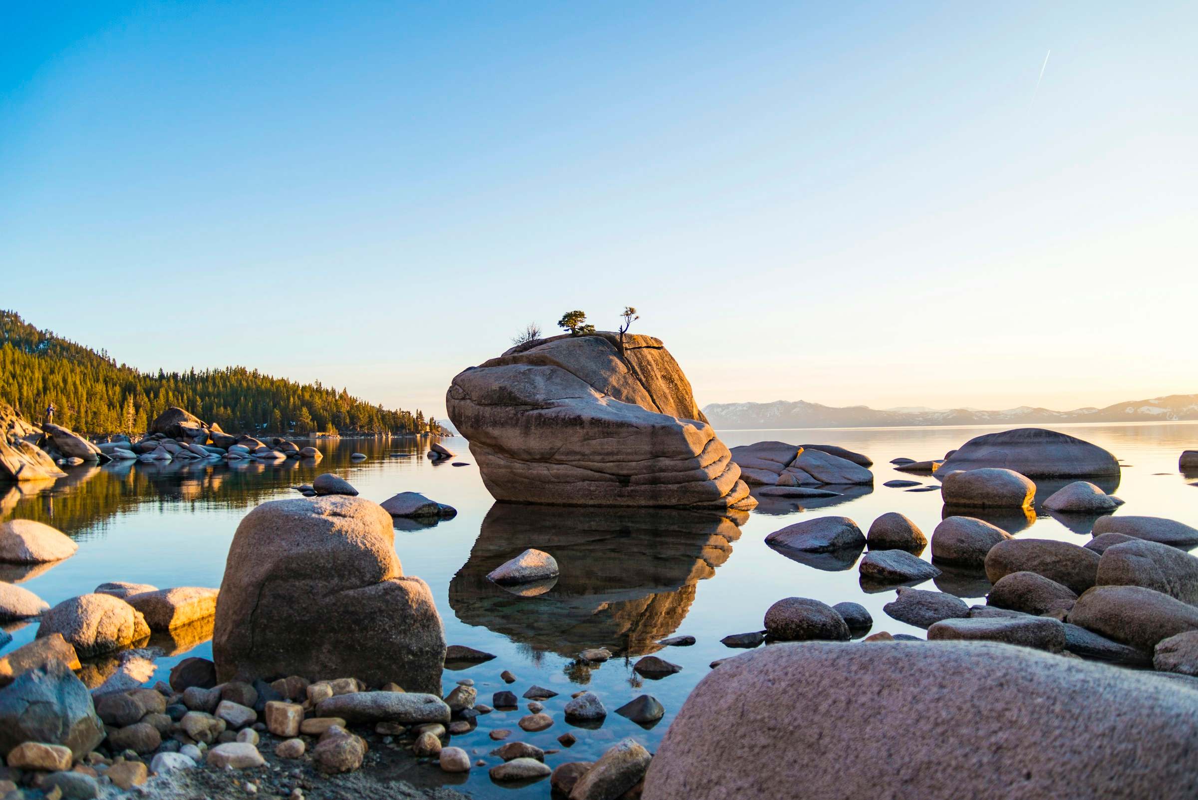 Granite boulders and glassy water on Lake Tahoe at golden hour