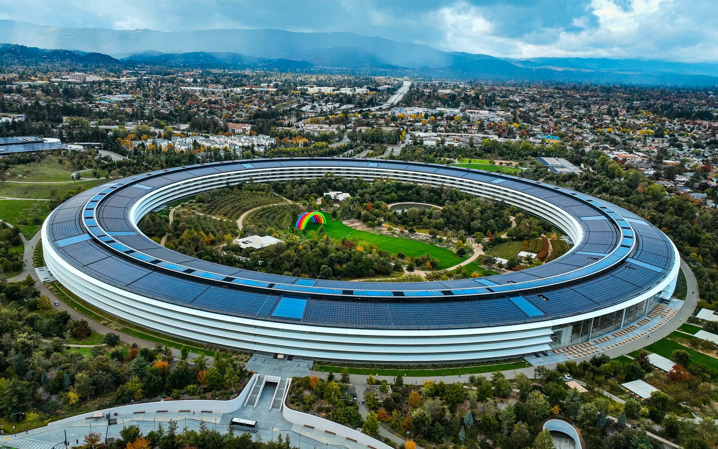 Aerial view of the ring-shaped Apple Park campus in Cupertino with hills behind