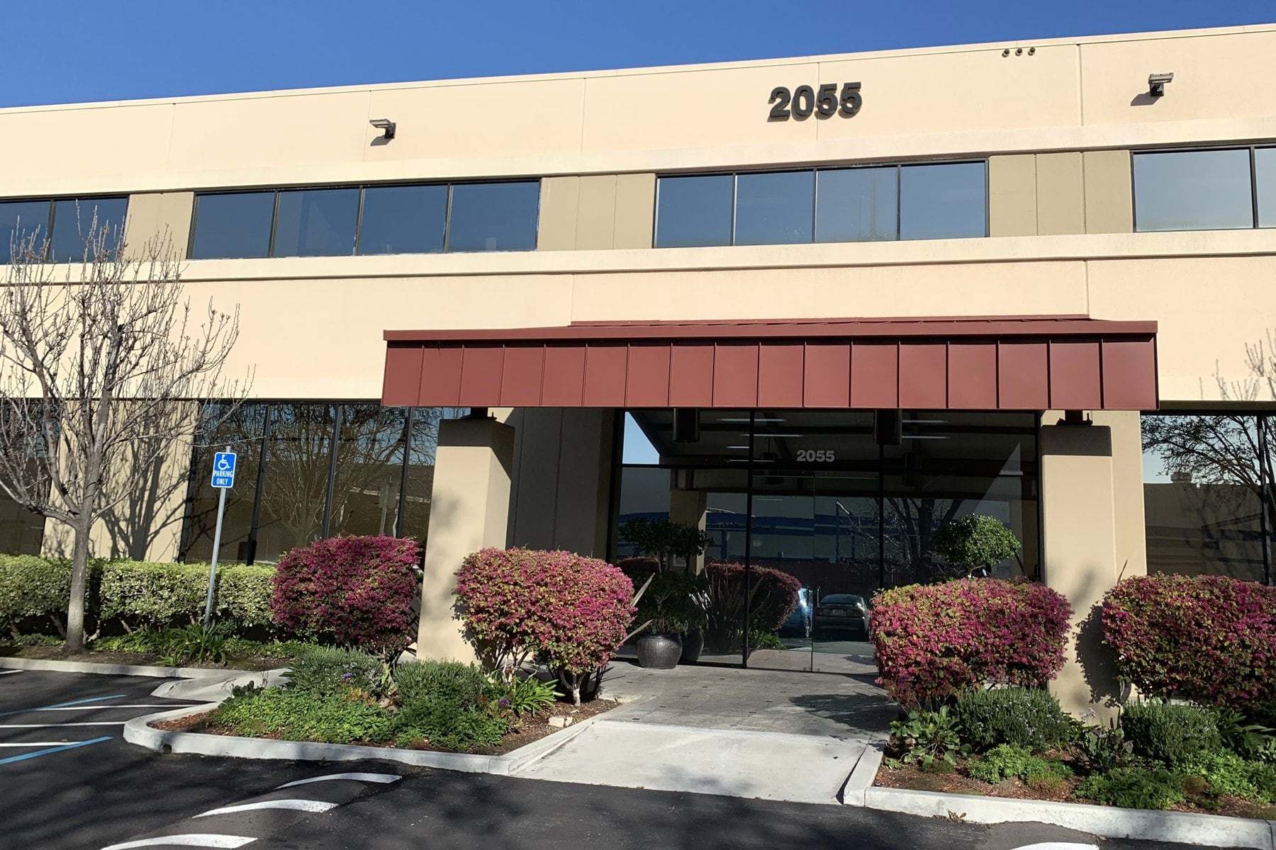 The 2055 Junction Avenue office building in North San Jose, with its entrance under a red awning
