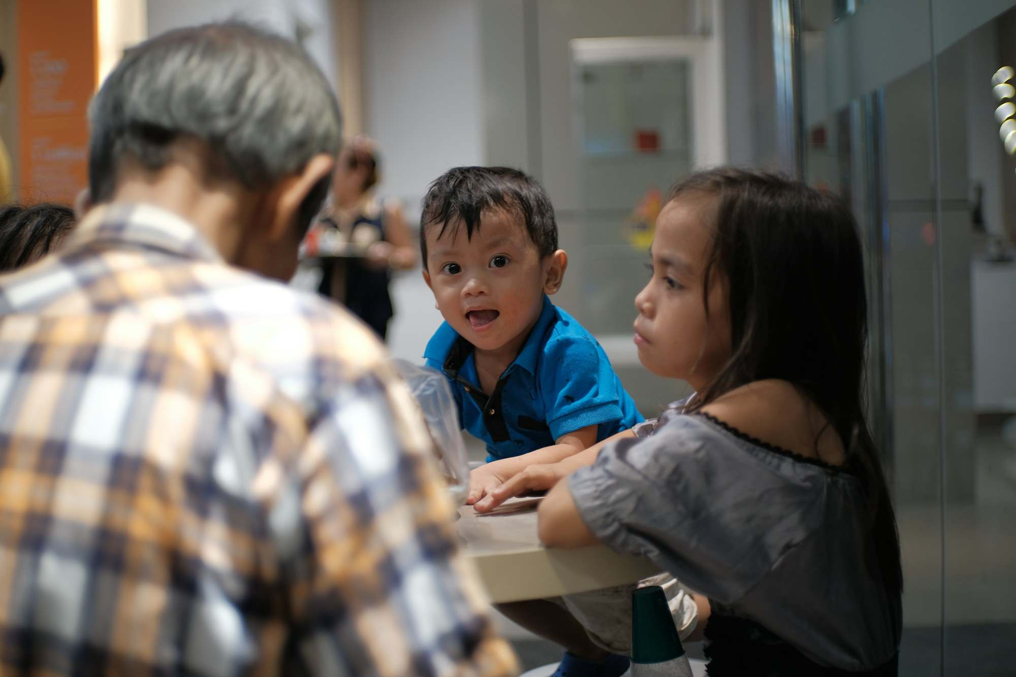 Grandfather sitting at the table with two grandchildren