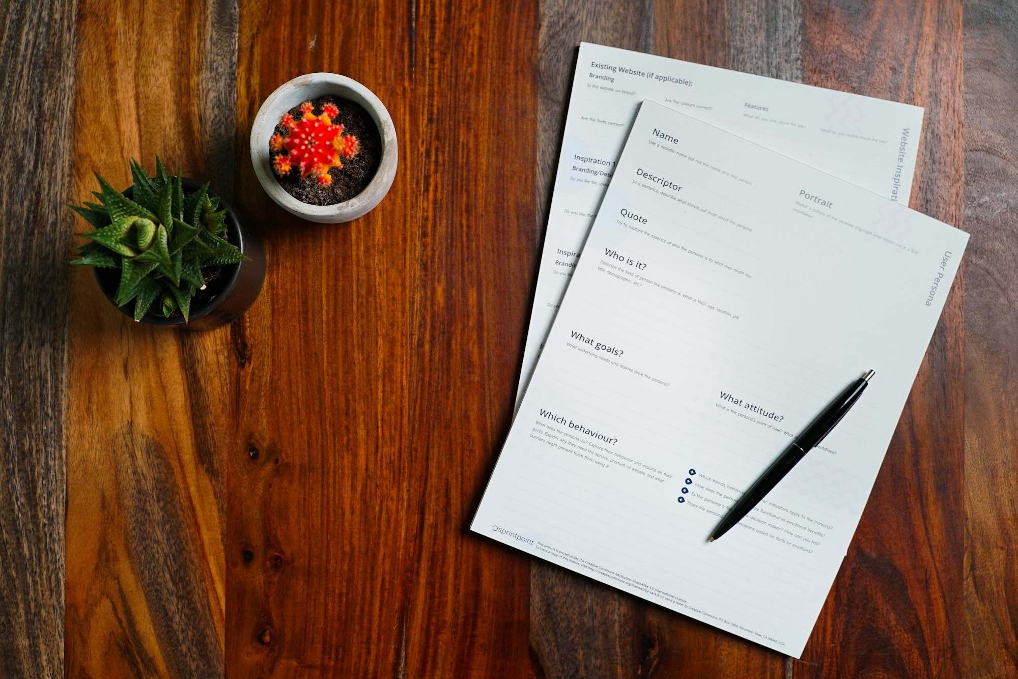 Papers and a pen on a wooden table