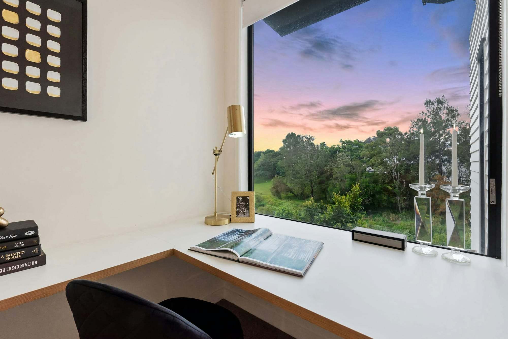 Desk by a large window with a view of hills
