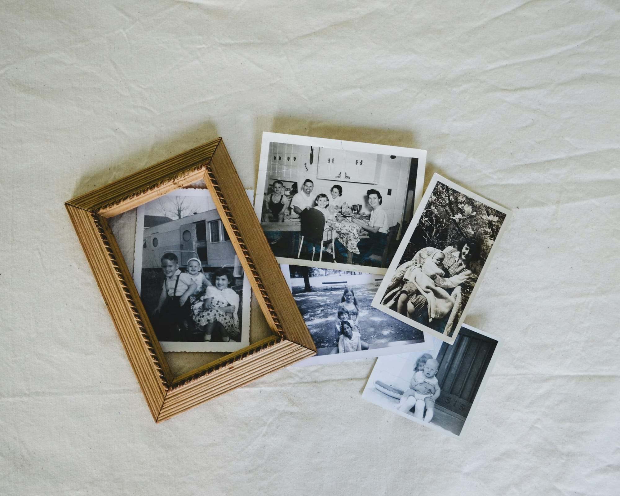 Old family photographs spread on a white table