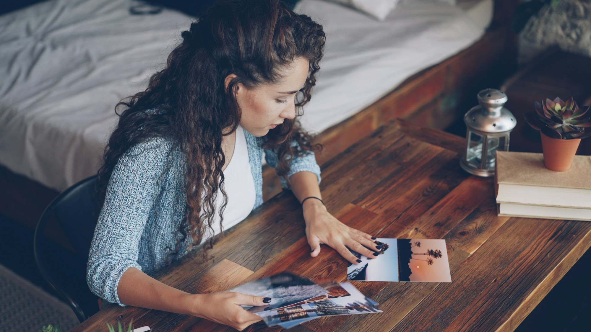 Woman sorting family photographs at a wooden table