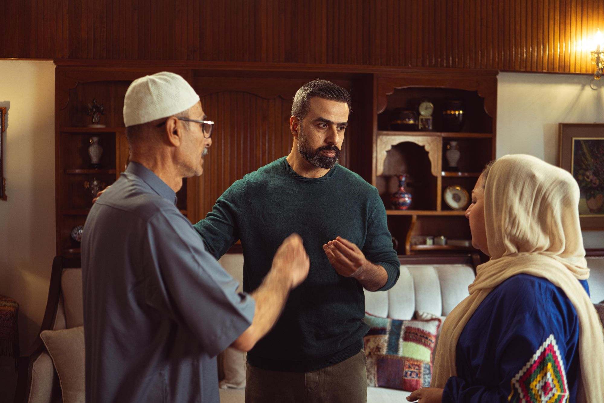 Three generations of a family in conversation in their living room